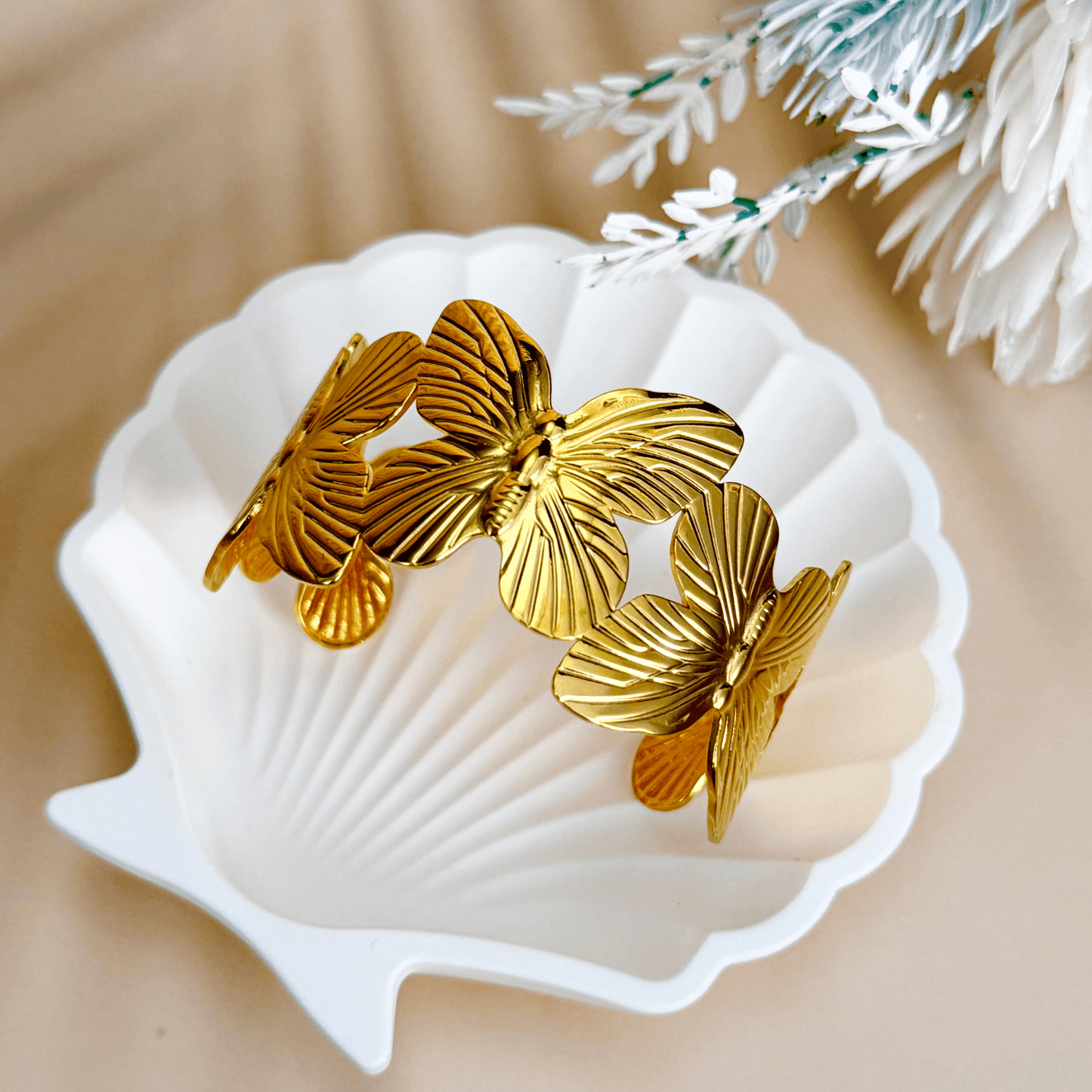 Waterproof gold butterfly bangle bracelet featuring layered sculpted butterflies in a detailed garden-inspired open cuff design, made with PVD gold plated stainless steel.