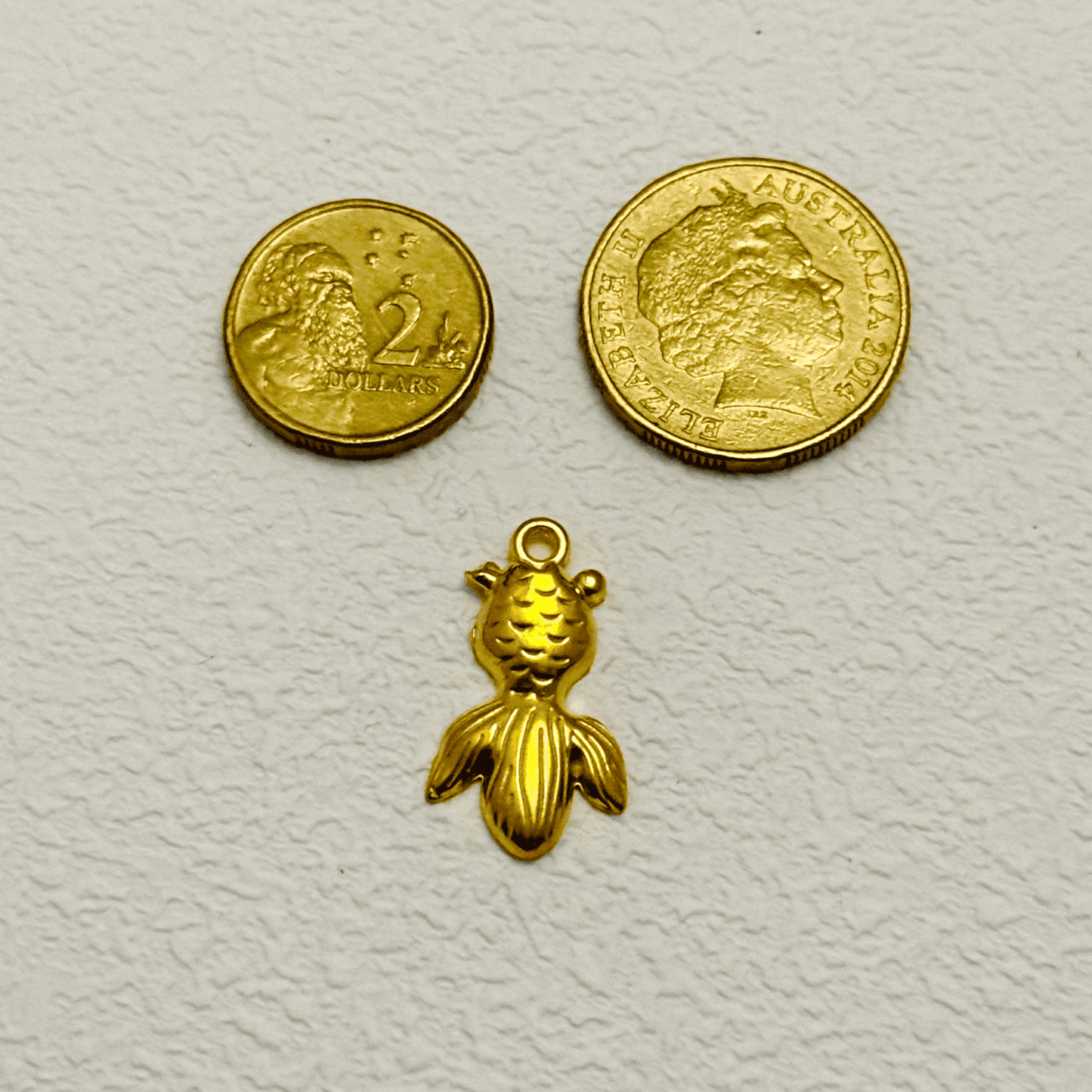 Gold goldfish charm with textured scales and a wide flowing tail