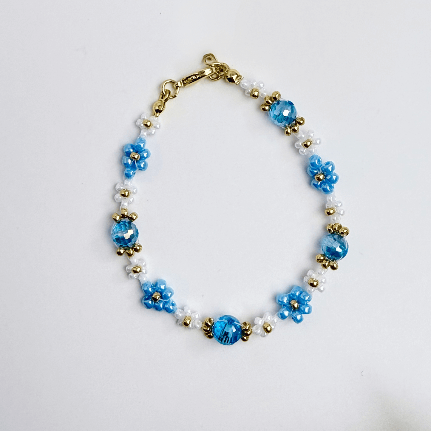 Handmade blue daisy flower beaded bracelet with Japanese glass beads and gold accents, available in gold or silver finish