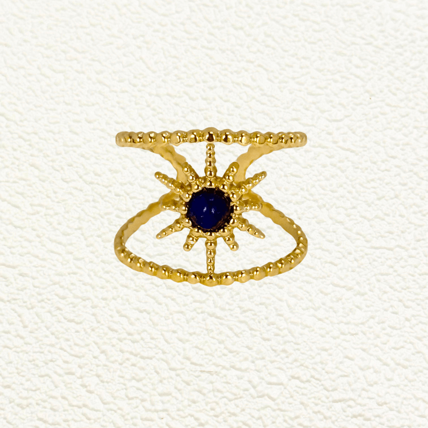 Lapis Sunburst Ring in gold with beaded twin bands and a navy lapis stone center. Waterproof and tarnish-resistant open ring with celestial sunburst design, worn on hand.