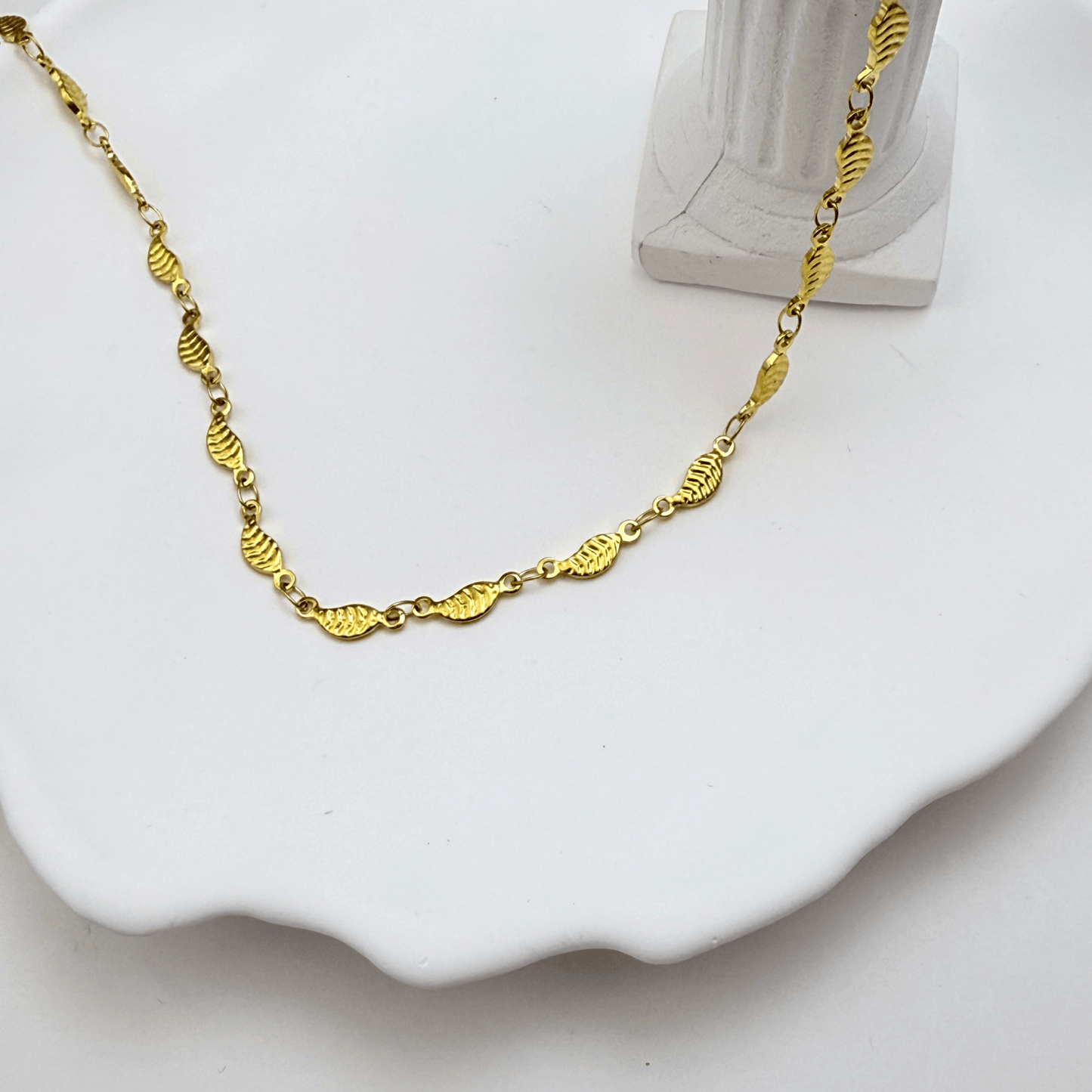 Elegant waterproof gold chain featuring textured leaf links with a minimalist, nature-inspired design
