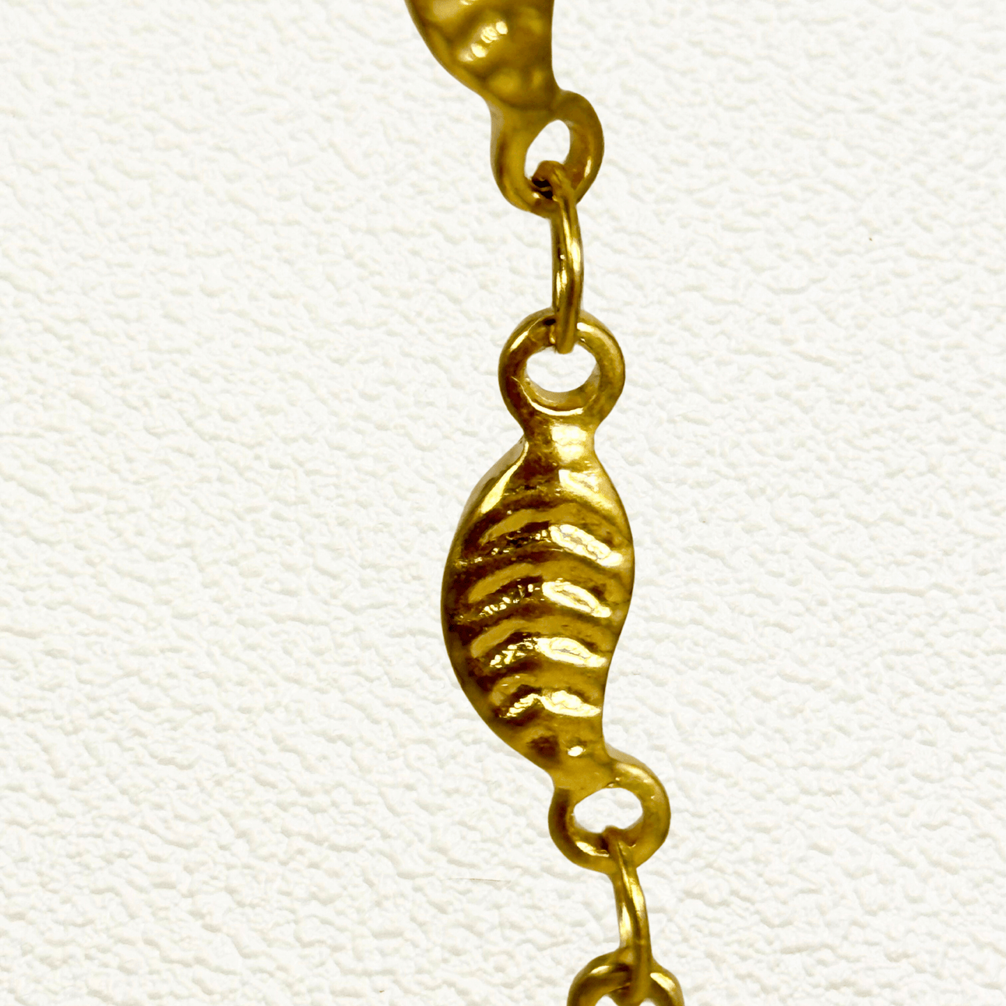 gold-toned leaf link chain made from stainless steel with delicate leaf-shaped links