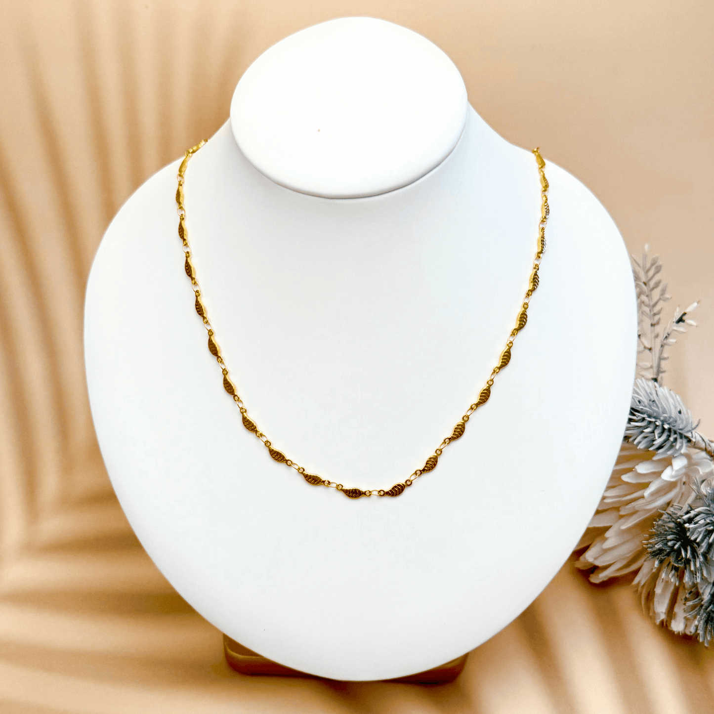 gold-toned leaf link chain made from stainless steel with delicate leaf-shaped links