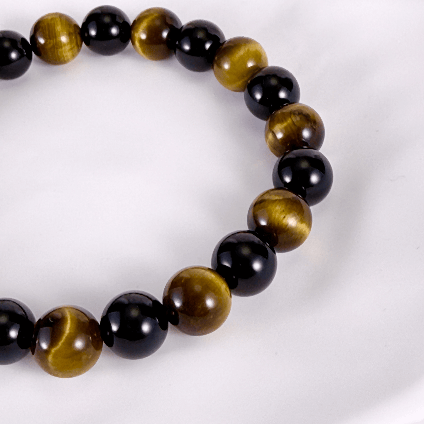 Handmade men’s bracelet with round black agate and tiger’s eye gemstone beads on elastic cord.