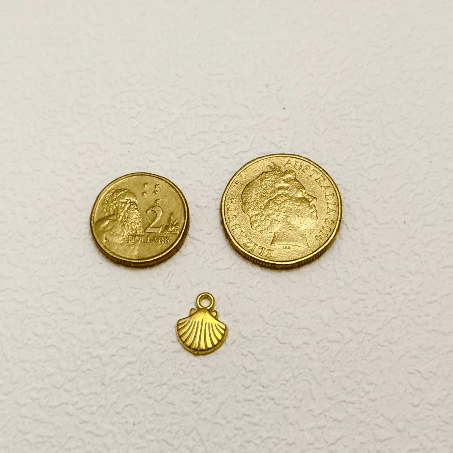 Gold scallop seashell charm with fine ridged texture, PVD gold plated finish