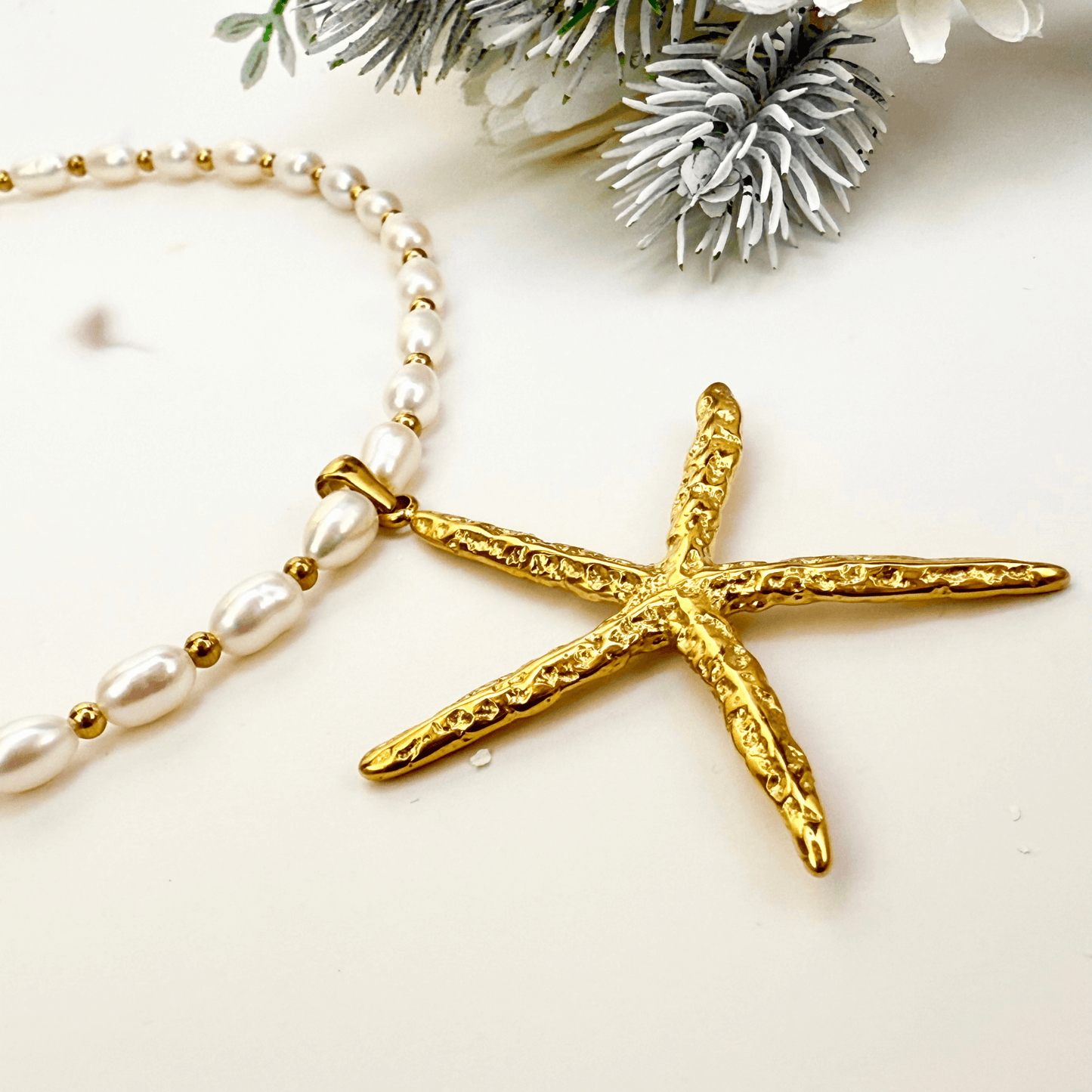 Bold gold starfish pendant on freshwater pearl necklace