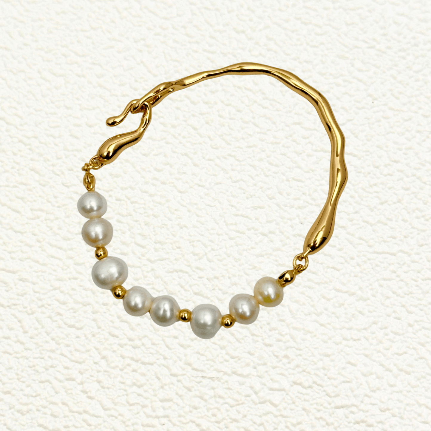 bracelet featuring freshwater pearls and sculptural molten gold band in an open, adjustable design