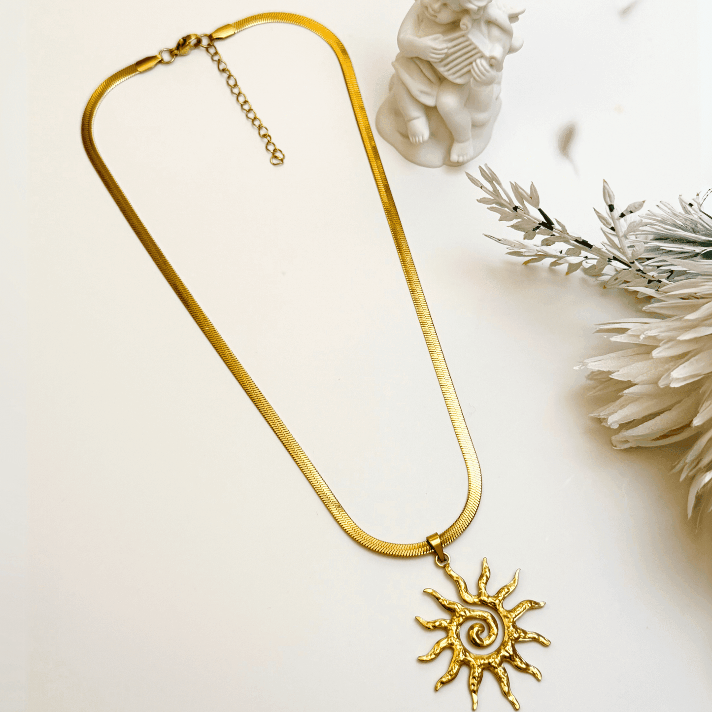 Radiant Sun pendant necklace in gold PVD steel with spiral sunburst design, celestial-themed statement jewellery.