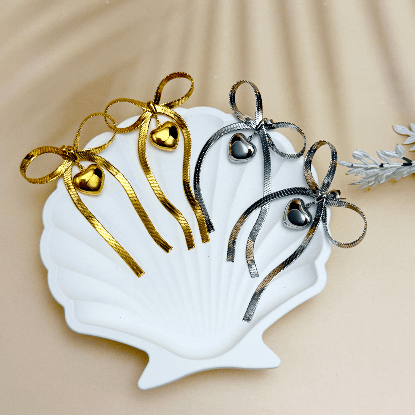 Ribbon bow drop earrings in gold and silver PVD plated stainless steel with long tails and polished heart charms