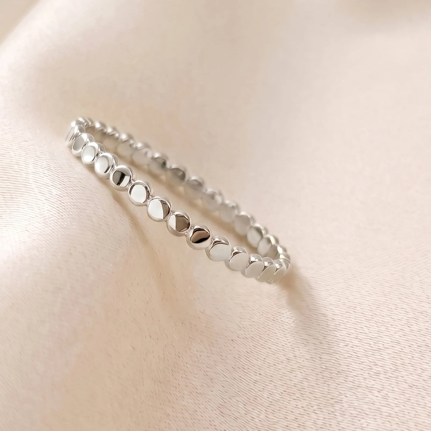 Dainty sterling silver stacking ring with small light-catching disc details