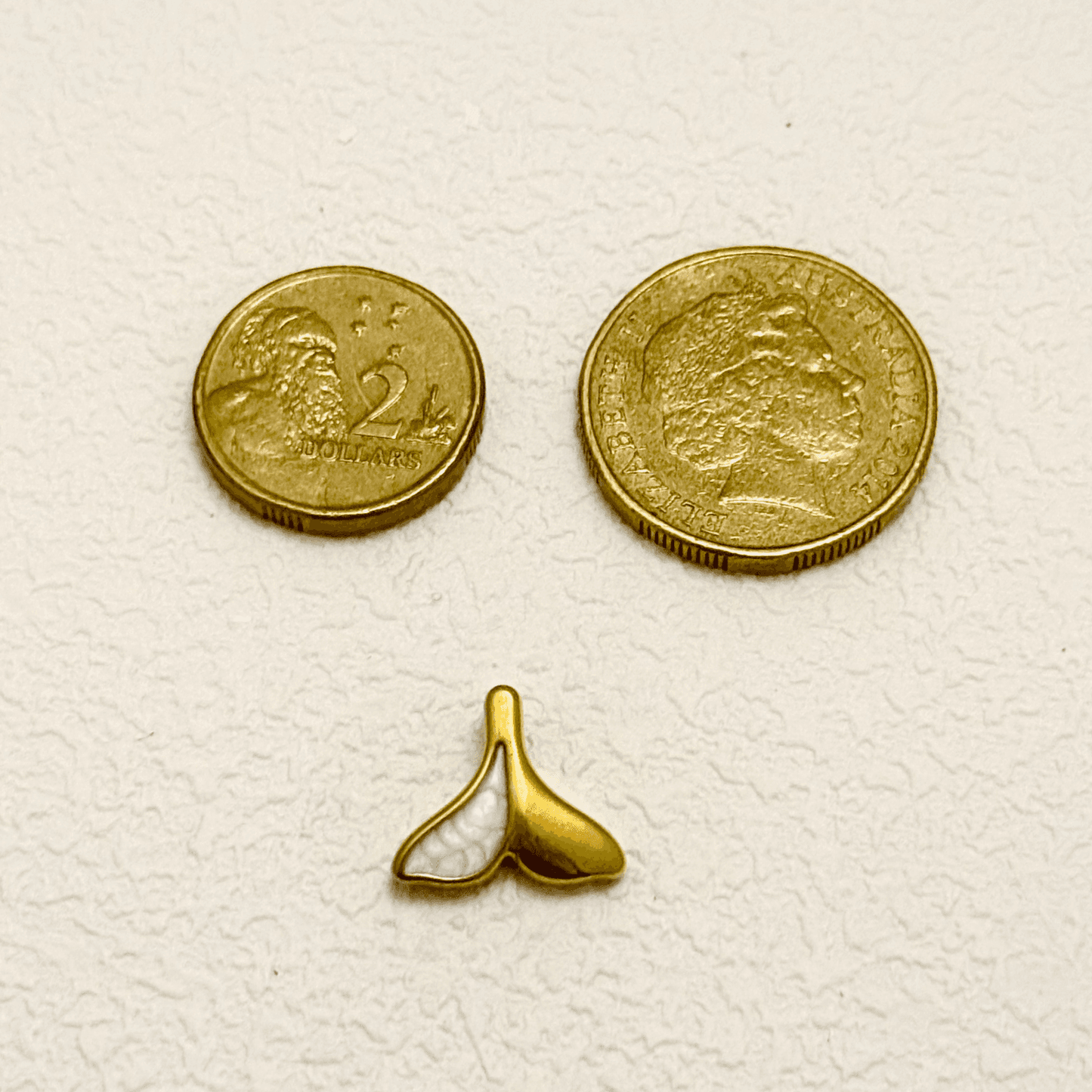 Gold whale tail charm with white enamel split design – ocean-themed pendant
