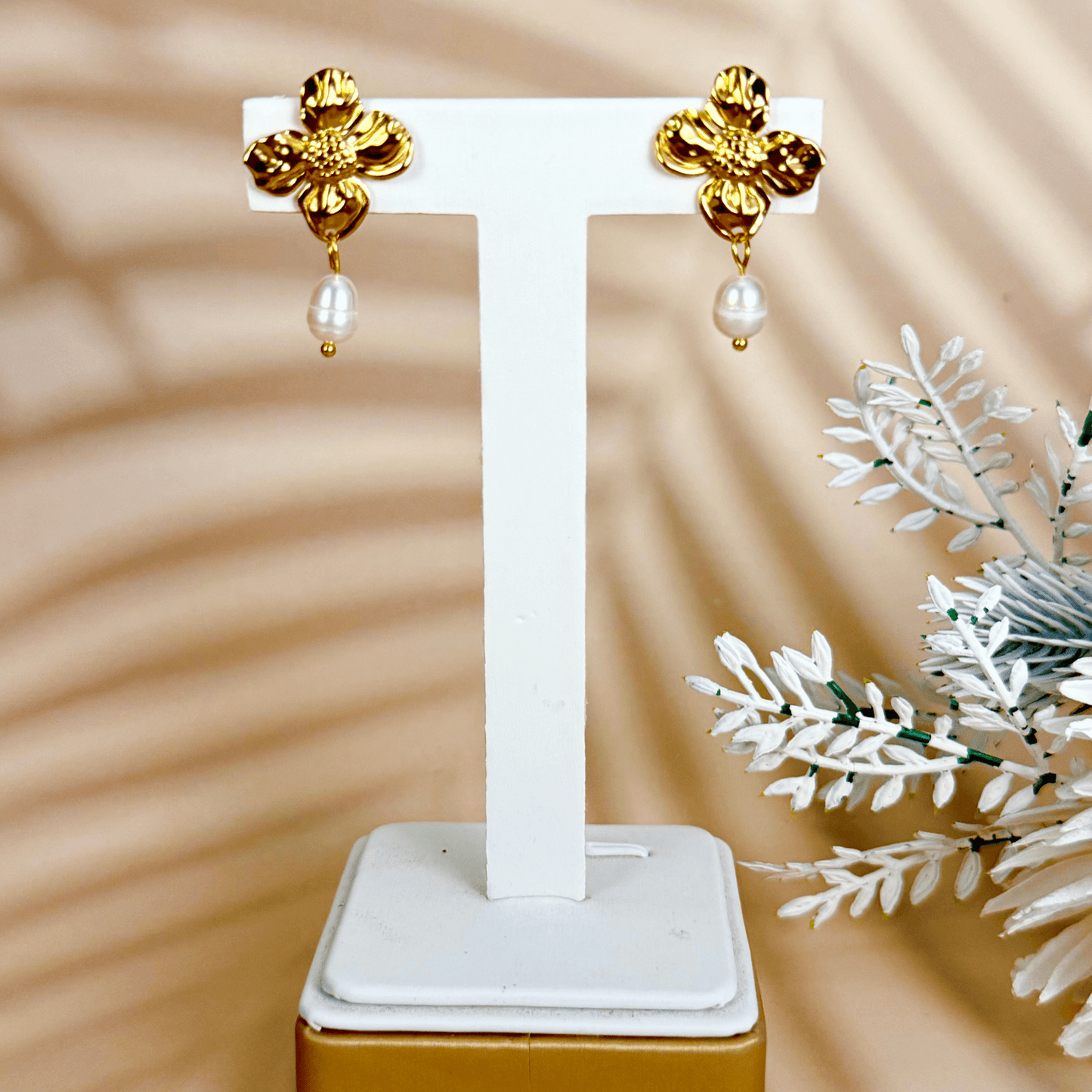 Textured gold floral pearl drop earrings with white teardrop-shaped pearls on waterproof stainless steel studs