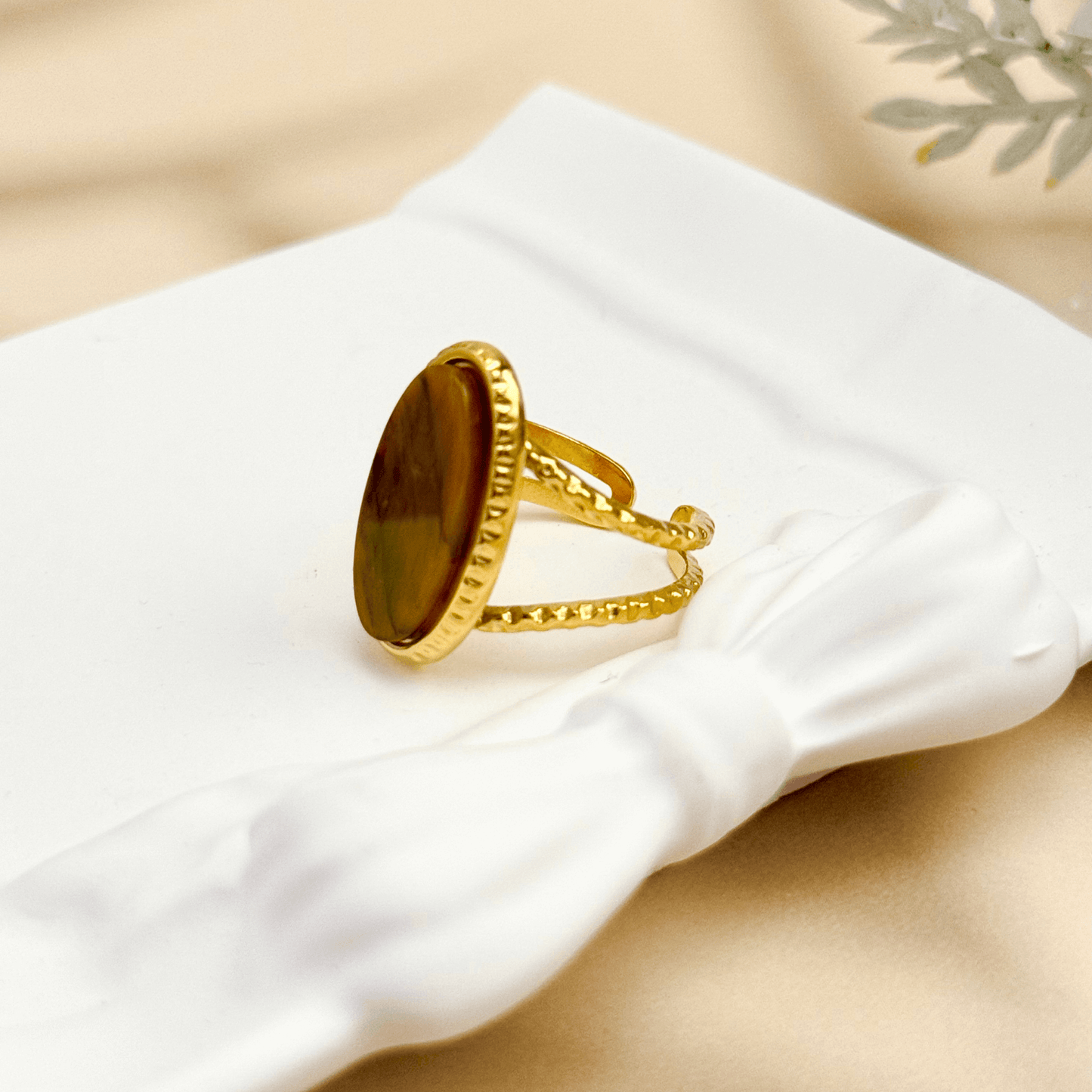 gold statement ring with large oval tiger eye stone and double textured band design.
