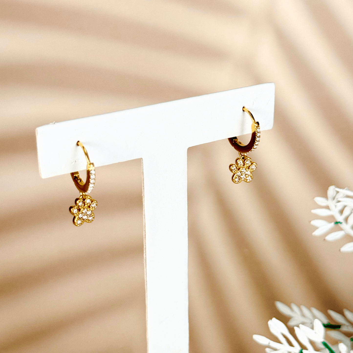 Tiny gold huggie earrings with a sparkling zircon-studded paw charm, waterproof hypoallergenic jewellery for animal lovers or pet parents