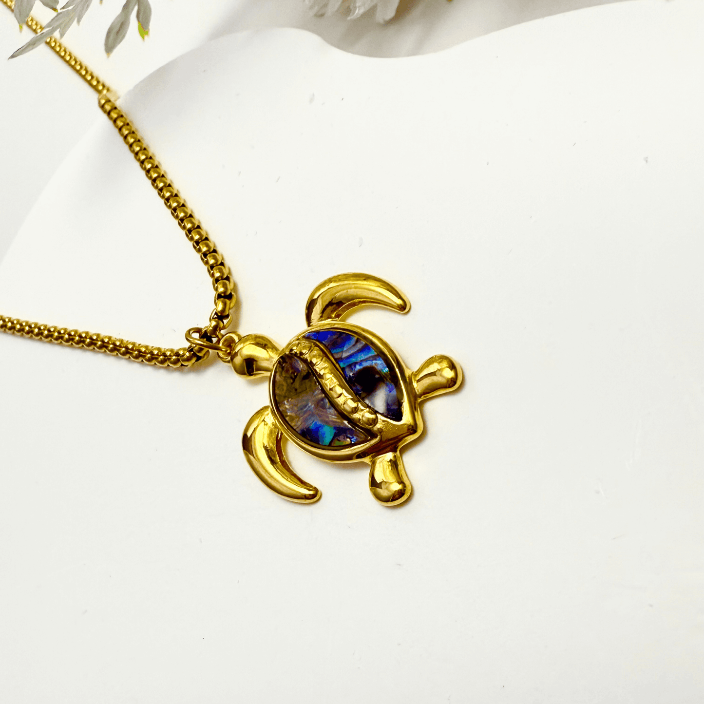 Waterproof gold turtle pendant necklace with abalone shell, shown on model with ocean-inspired details