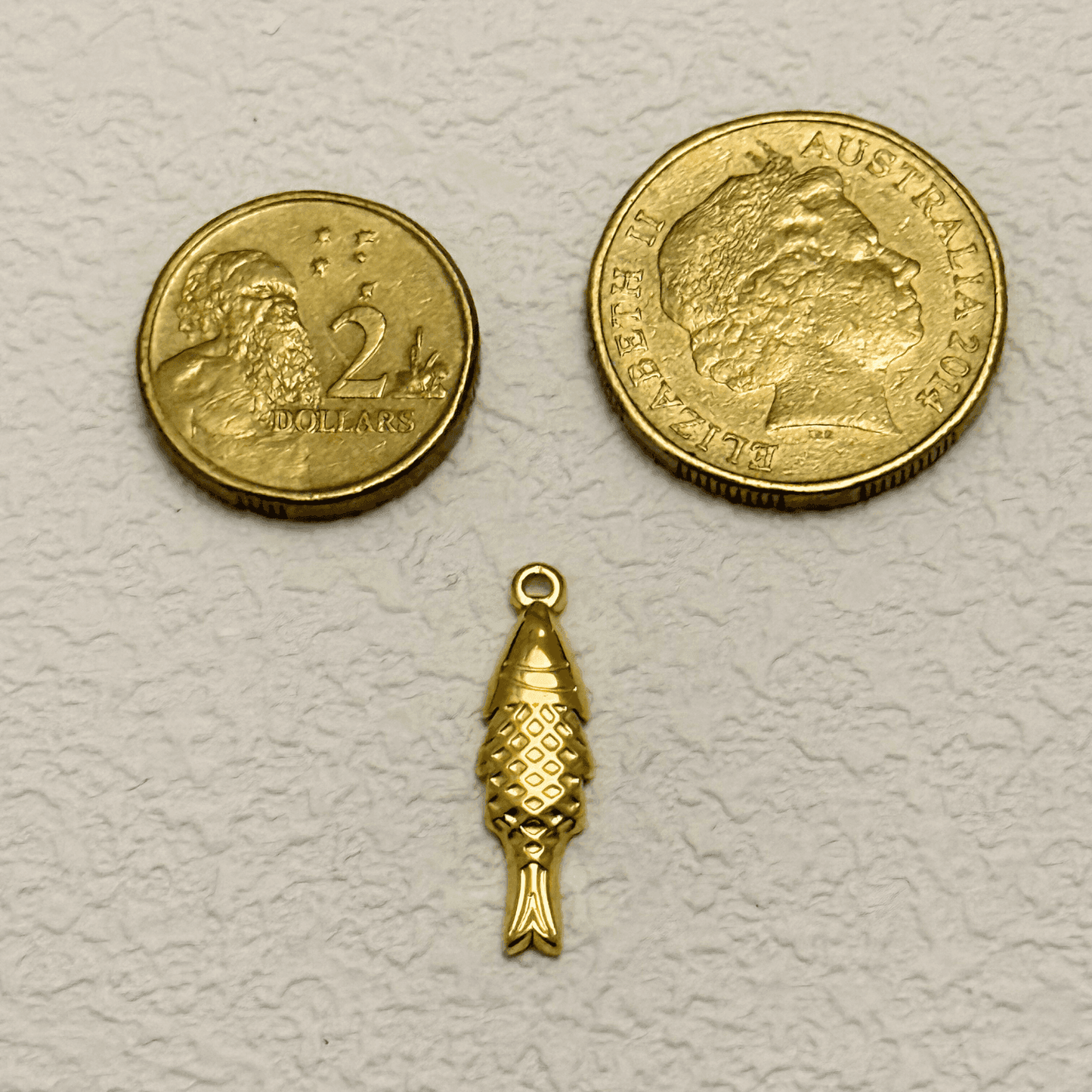 Gold vertical fish charm with diamond scale texture and detailed tail