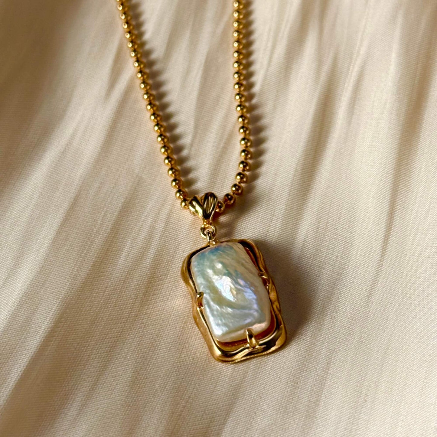 vintage baroque pearl pendant necklace with rectangular pearl and gold-plated silver beaded chain displayed on a jewellery bust