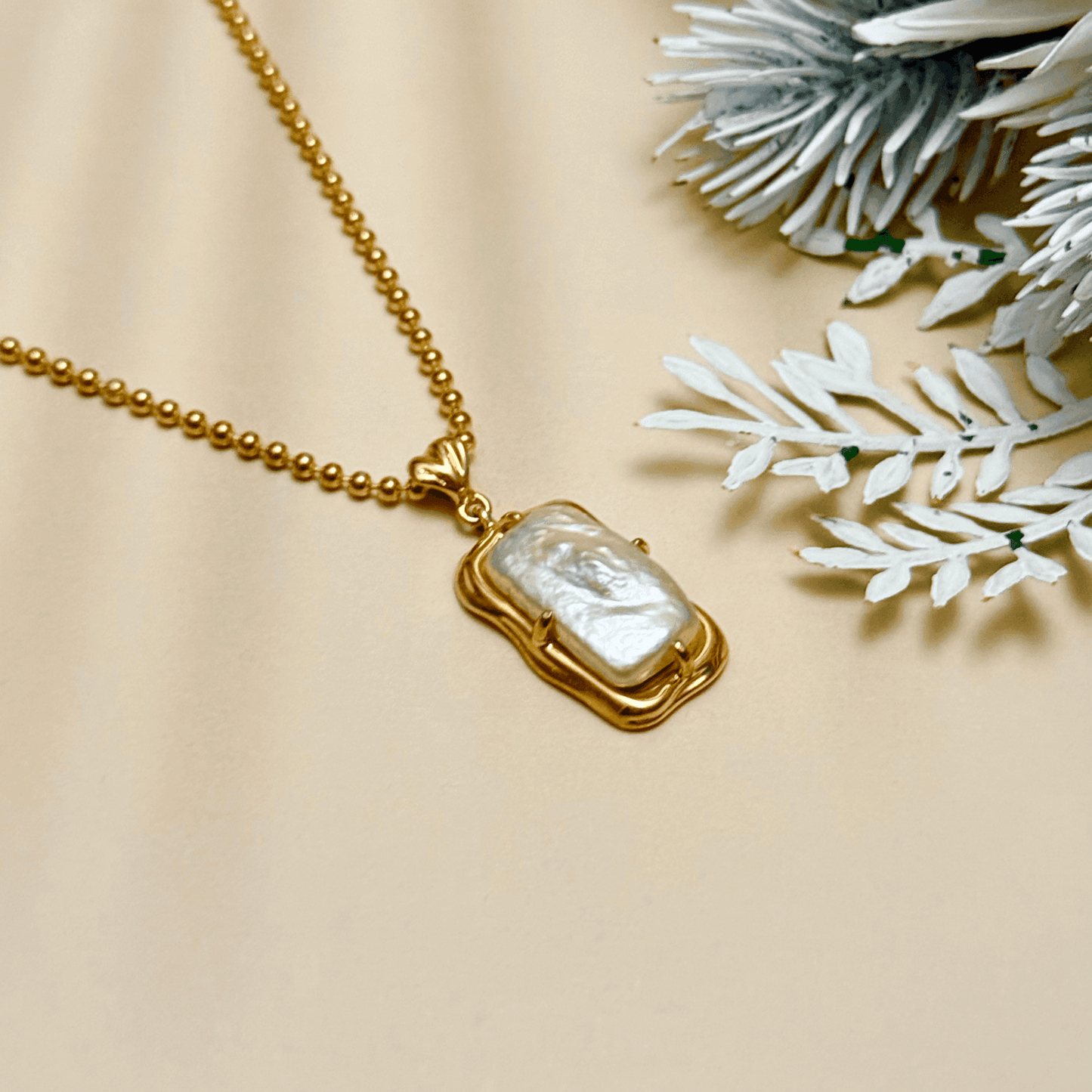 vintage baroque pearl pendant necklace with rectangular pearl and gold-plated silver beaded chain displayed on a jewellery bust
