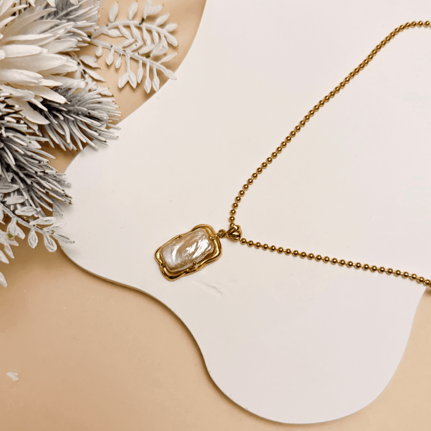 vintage baroque pearl pendant necklace with rectangular pearl and gold-plated silver beaded chain displayed on a jewellery bust