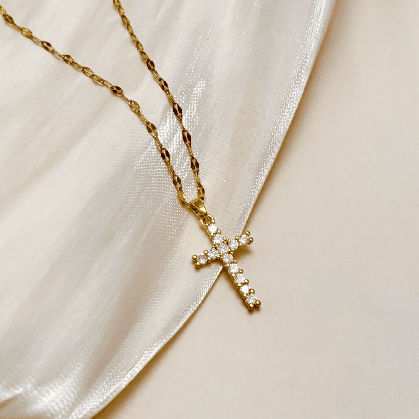 Gold-plated zircon cross pendant necklace with textured link chain, shown on display and close-up views – MXW Jewellery.