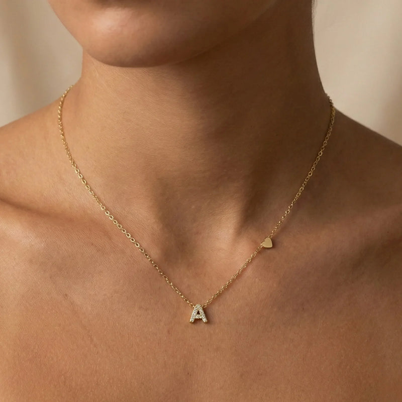 A woman wearing a layered gold necklace collection featuring various chain styles and a heart pendant, showcasing elegant and versatile gold jewellery for everyday and special occasions.