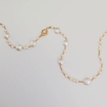 Gold vermeil necklace of coin and round freshwater pearls with small gold beads and a sculpted daisy connector
