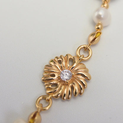 Gold vermeil necklace of coin and round freshwater pearls with small gold beads and a sculpted daisy connector