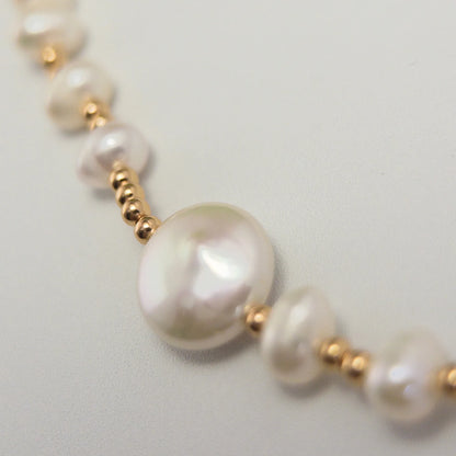 Gold vermeil necklace of coin and round freshwater pearls with small gold beads and a sculpted daisy connector