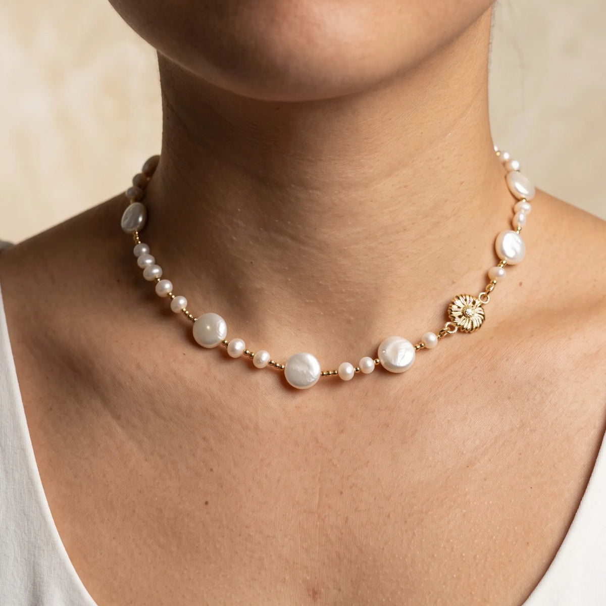 Gold vermeil necklace of coin and round freshwater pearls with small gold beads and a sculpted daisy connector