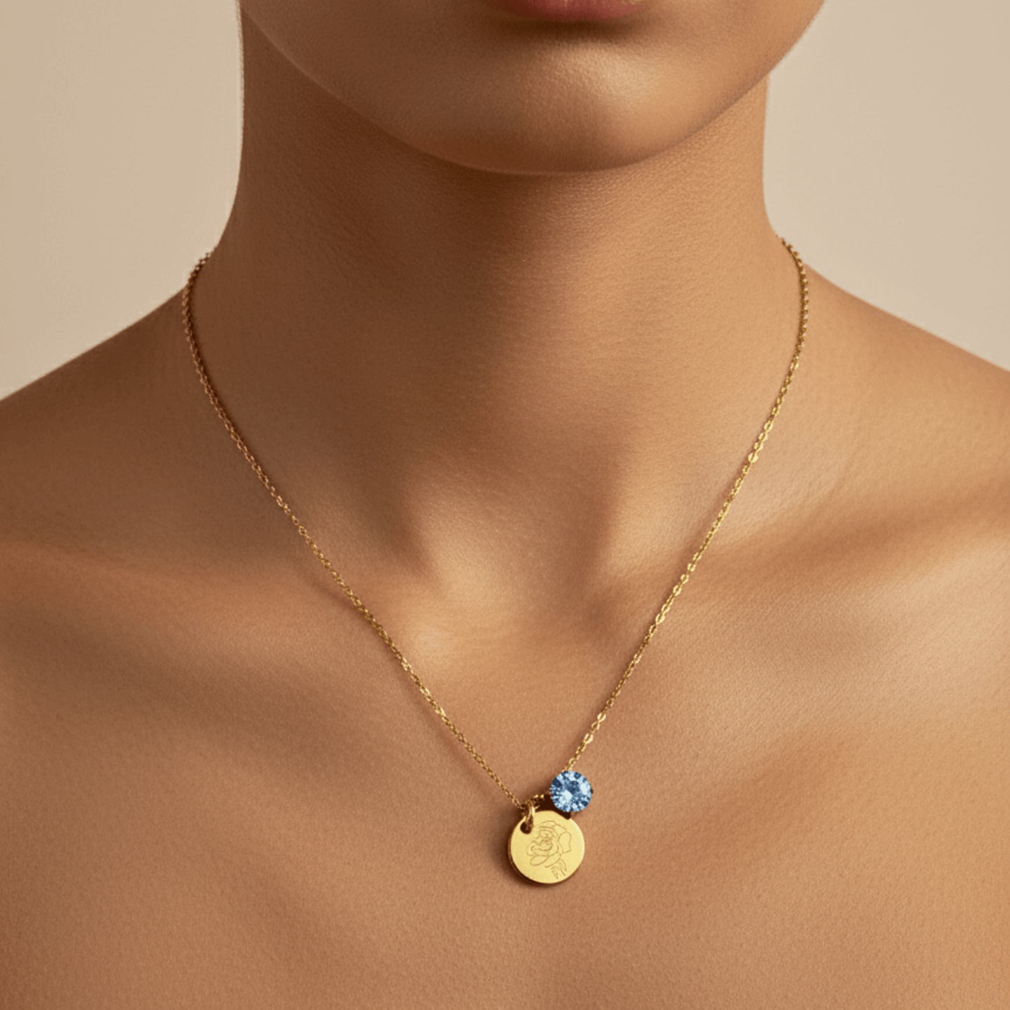 gold birth month necklace with blue crystal and engraved flower pendant