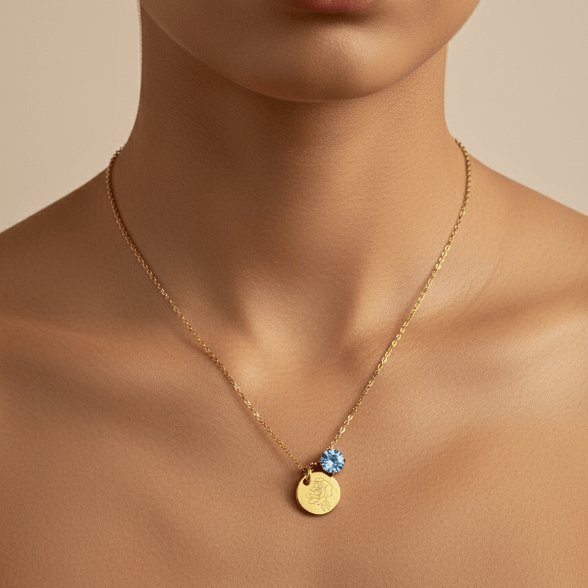 gold birth month necklace with blue crystal and engraved flower pendant