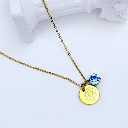 gold birth month necklace with blue crystal and engraved flower pendant