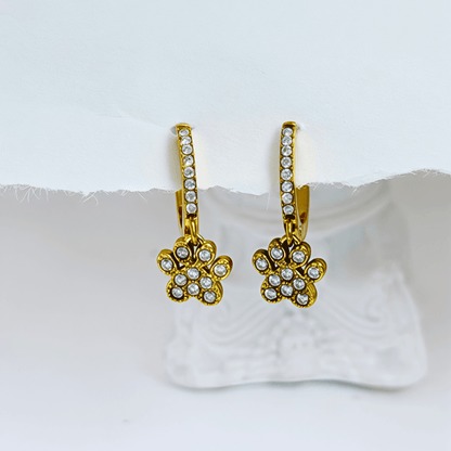 Close up of Gold Paw Print Huggie Earrings featuring paved crystals and a high-polish finish by MXW Jewellery