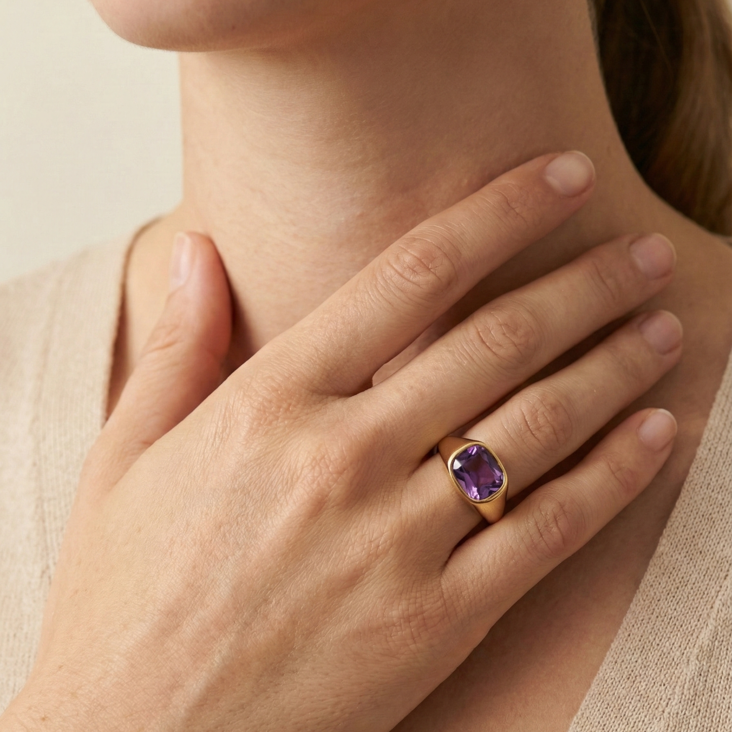 Gold ring with a cushion-cut amethyst-purple zircon gemstone.