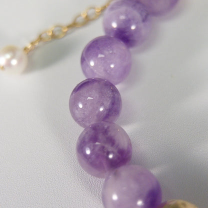 A beaded bracelet featuring Amethyst beads, premium freshwater pearl, and stamped initial disc, 14k gold filled. MXW Jewellery.