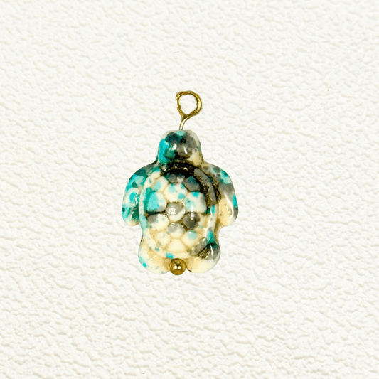 Turquoise-toned synthetic stone turtle charm with hexagonal mosaic shell pattern and gold bead detail