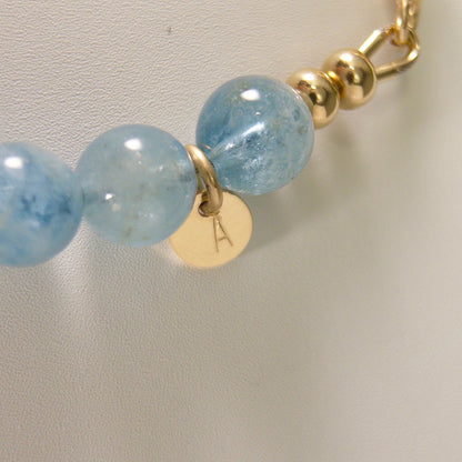 Aquamarine, pearl and initial gold bracelet featuring AAA-grade aquamarine beads, lustrous pearls and a personalised gold-filled stamped initial disc.