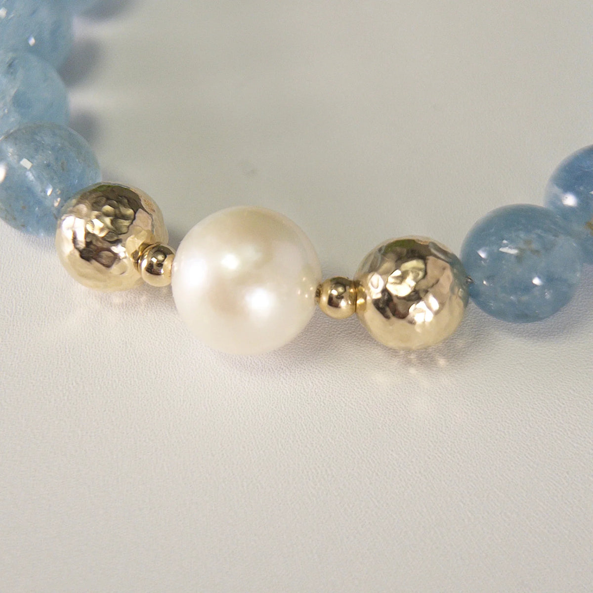 Aquamarine, pearl and initial gold bracelet featuring AAA-grade aquamarine beads, lustrous pearls and a personalised gold-filled stamped initial disc.