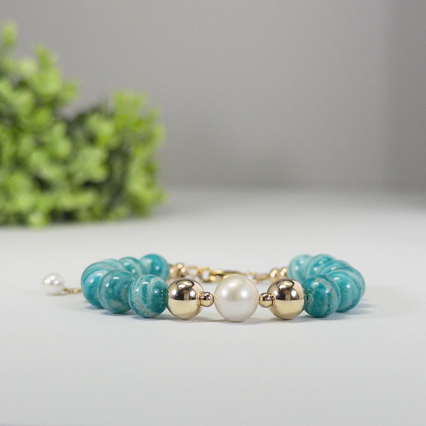 A beaded bracelet featuring banded amazonite gemstone beads, premium freshwater pearl, and personalised stamped initial disc, 14k gold filled. MXW Jewellery