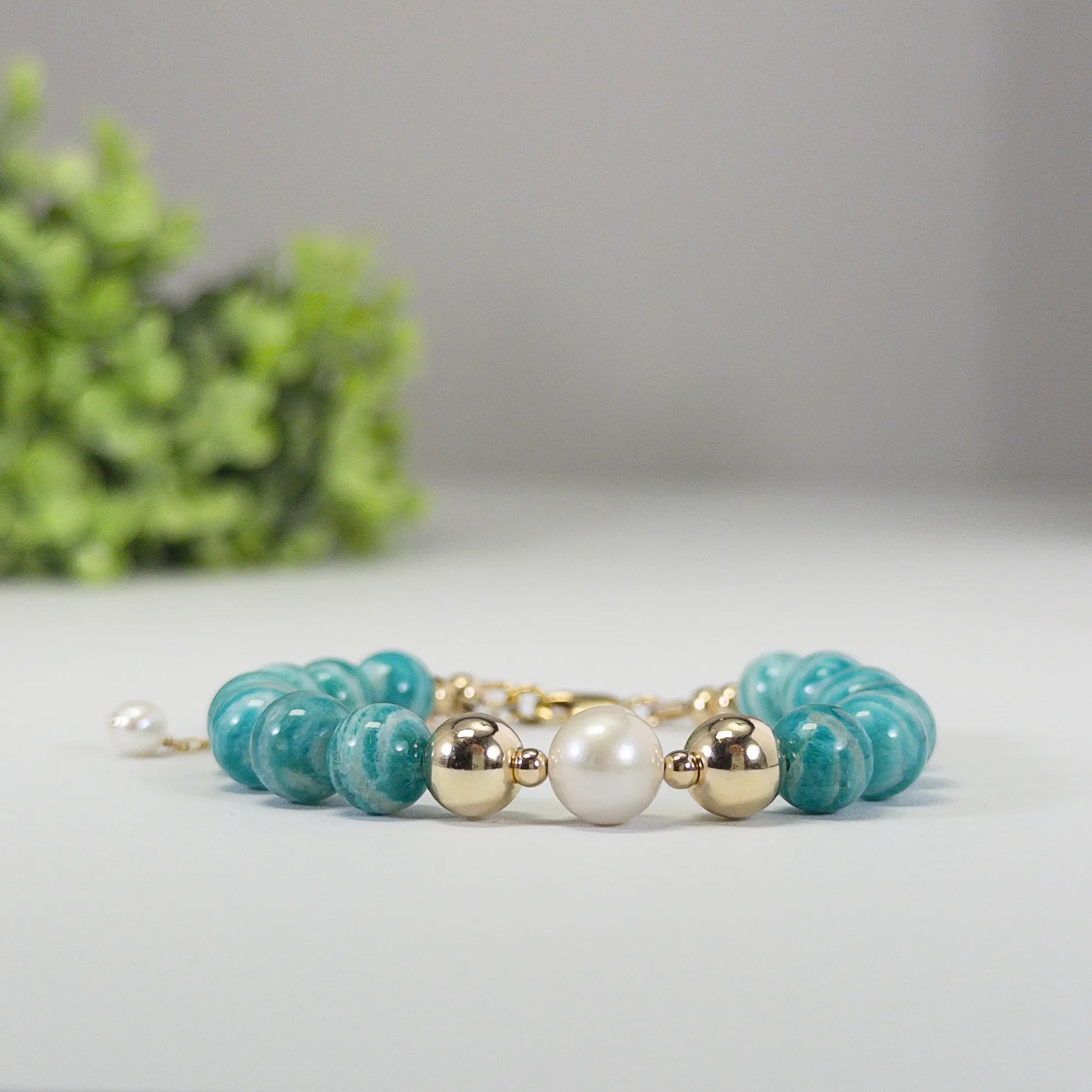 A beaded bracelet featuring banded amazonite gemstone beads, premium freshwater pearl, and personalised stamped initial disc, 14k gold filled. MXW Jewellery