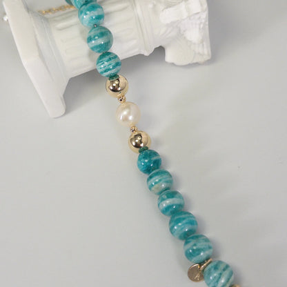 A beaded bracelet featuring banded amazonite gemstone beads, premium freshwater pearl, and personalised stamped initial disc, 14k gold filled. MXW Jewellery