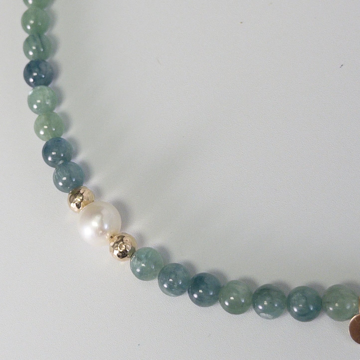 Bicolor kyanite, pearl and initial gold bracelet featuring naturally zoned blue-green gemstone beads, lustrous freshwater pearls and a personalised gold-filled stamped initial disc.