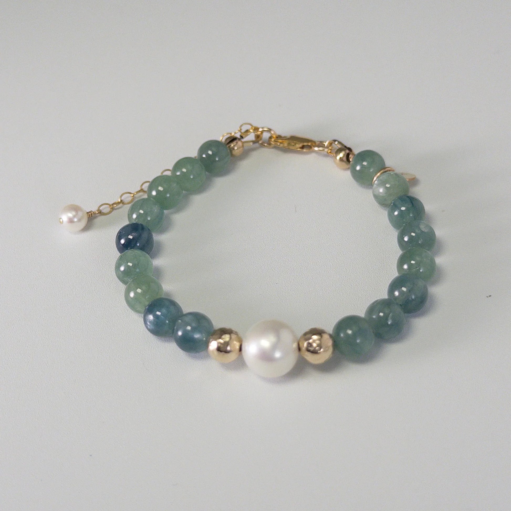 Bicolor kyanite, pearl and initial gold bracelet featuring naturally zoned blue-green gemstone beads, lustrous freshwater pearls and a personalised gold-filled stamped initial disc.