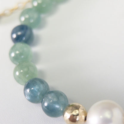 Bicolor kyanite, pearl and initial gold bracelet featuring naturally zoned blue-green gemstone beads, lustrous freshwater pearls and a personalised gold-filled stamped initial disc.
