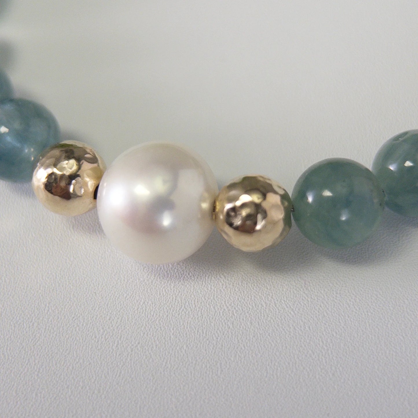 Bicolor kyanite, pearl and initial gold bracelet featuring naturally zoned blue-green gemstone beads, lustrous freshwater pearls and a personalised gold-filled stamped initial disc.