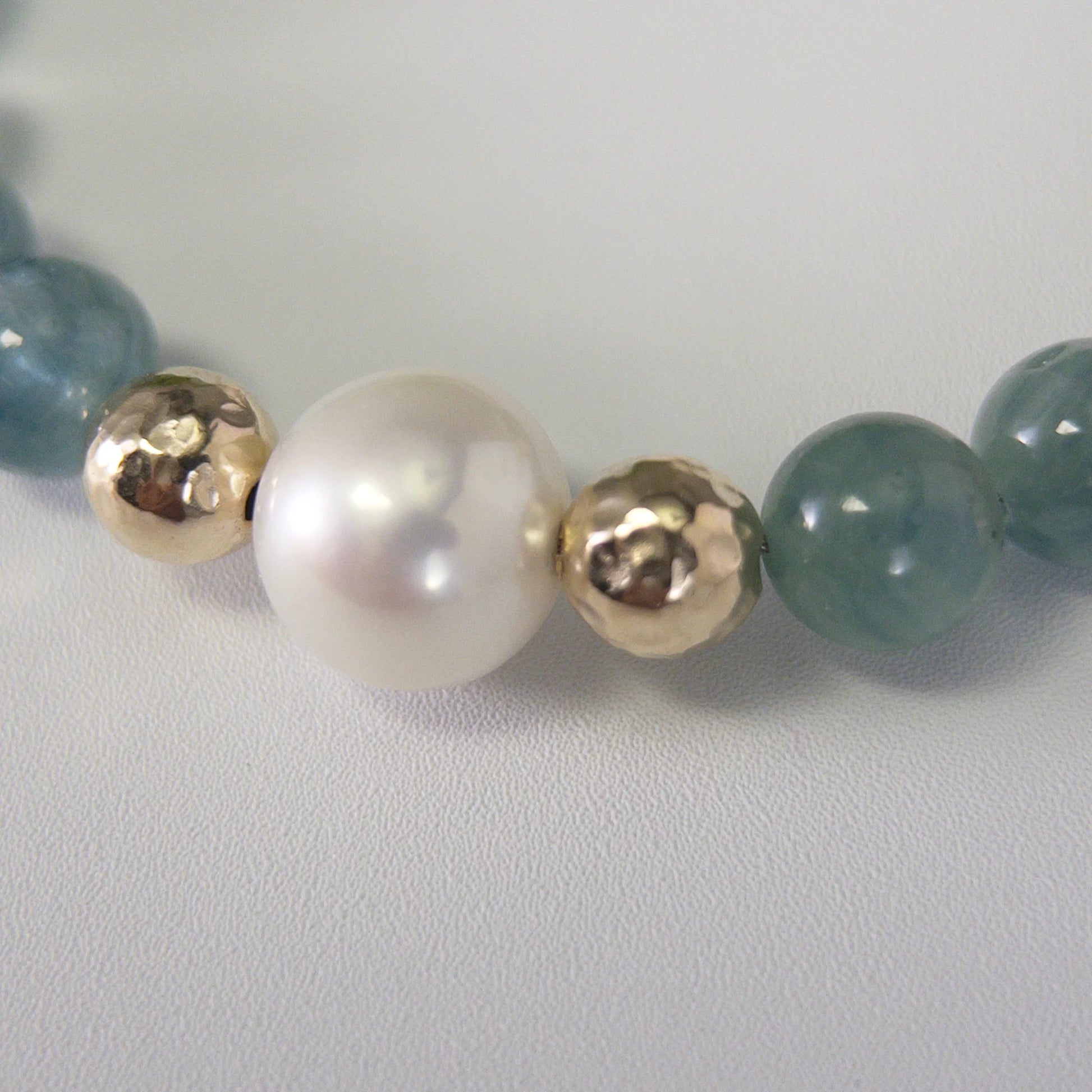 Bicolor kyanite, pearl and initial gold bracelet featuring naturally zoned blue-green gemstone beads, lustrous freshwater pearls and a personalised gold-filled stamped initial disc.