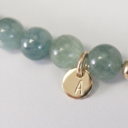 Bicolor kyanite, pearl and initial gold bracelet featuring naturally zoned blue-green gemstone beads, lustrous freshwater pearls and a personalised gold-filled stamped initial disc.