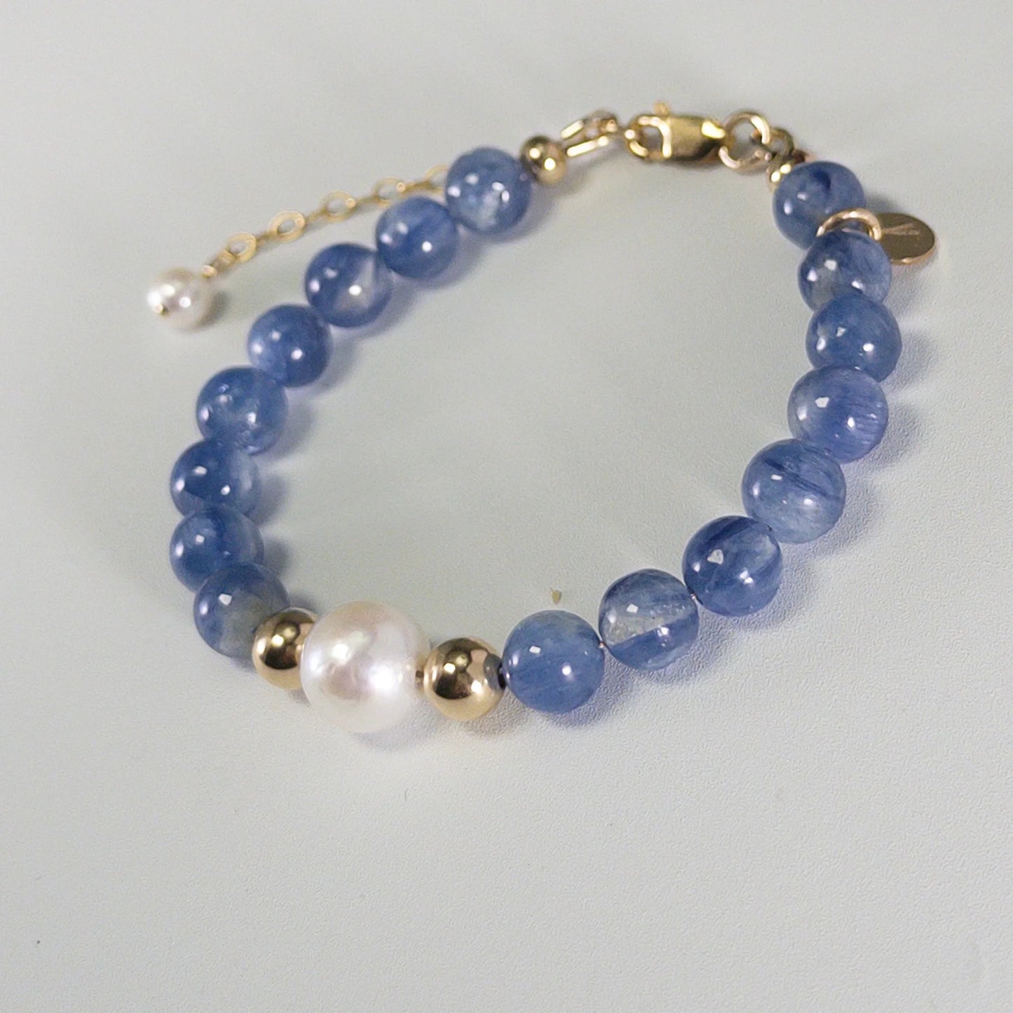 Blue kyanite, pearl and initial gold bracelet featuring Brazilian blue kyanite beads, lustrous freshwater pearls and a personalised gold-filled stamped initial disc.