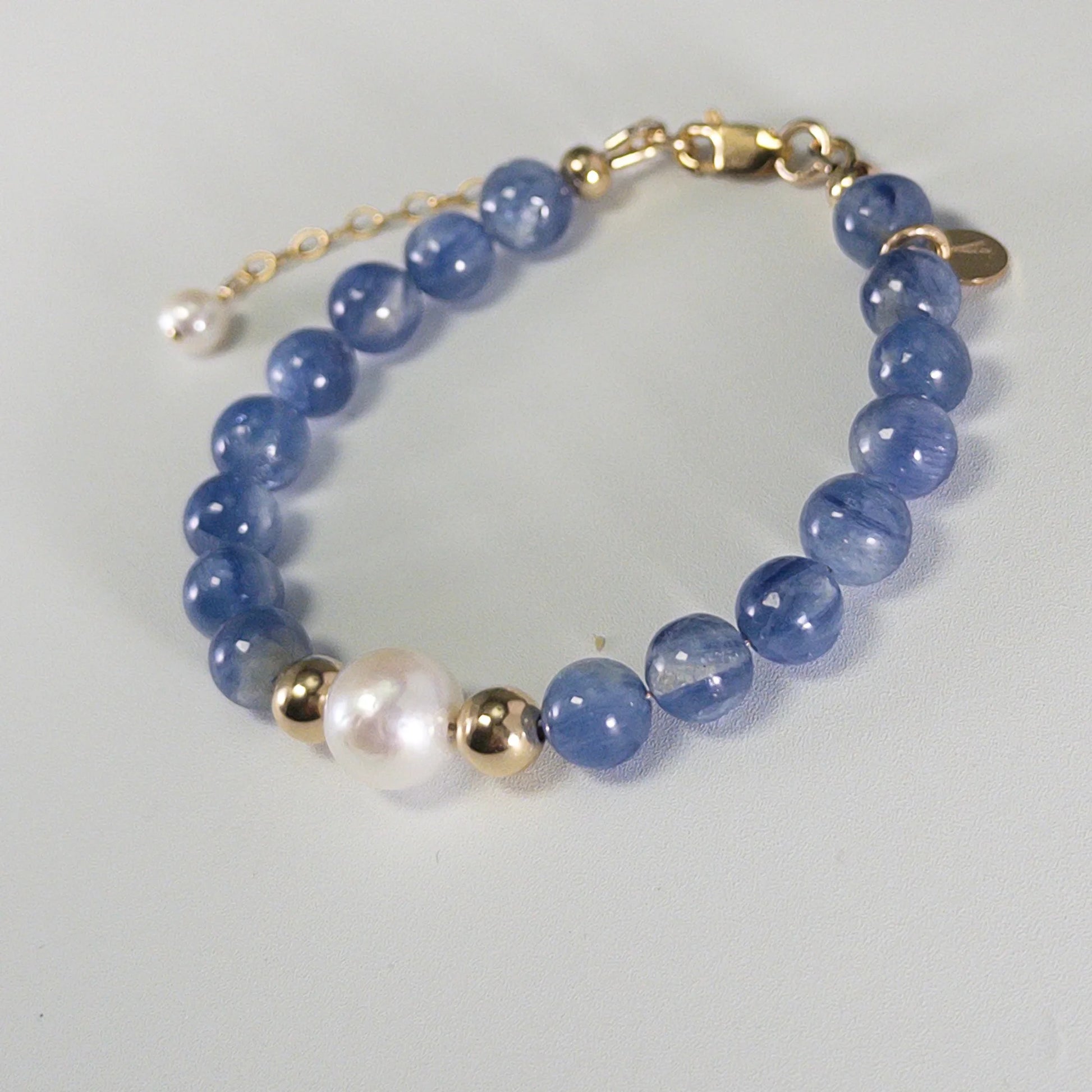 Blue kyanite, pearl and initial gold bracelet featuring Brazilian blue kyanite beads, lustrous freshwater pearls and a personalised gold-filled stamped initial disc.