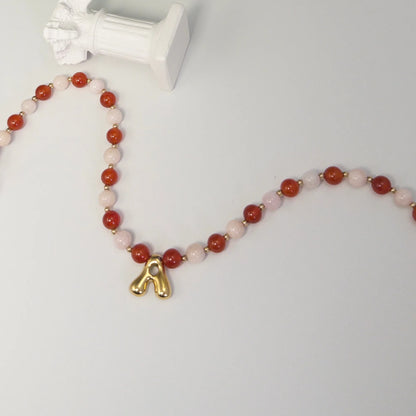 personalised 14K gold filled necklace with alternating carnelian and pink morganite beads, gold spacers and bubble initial letter.